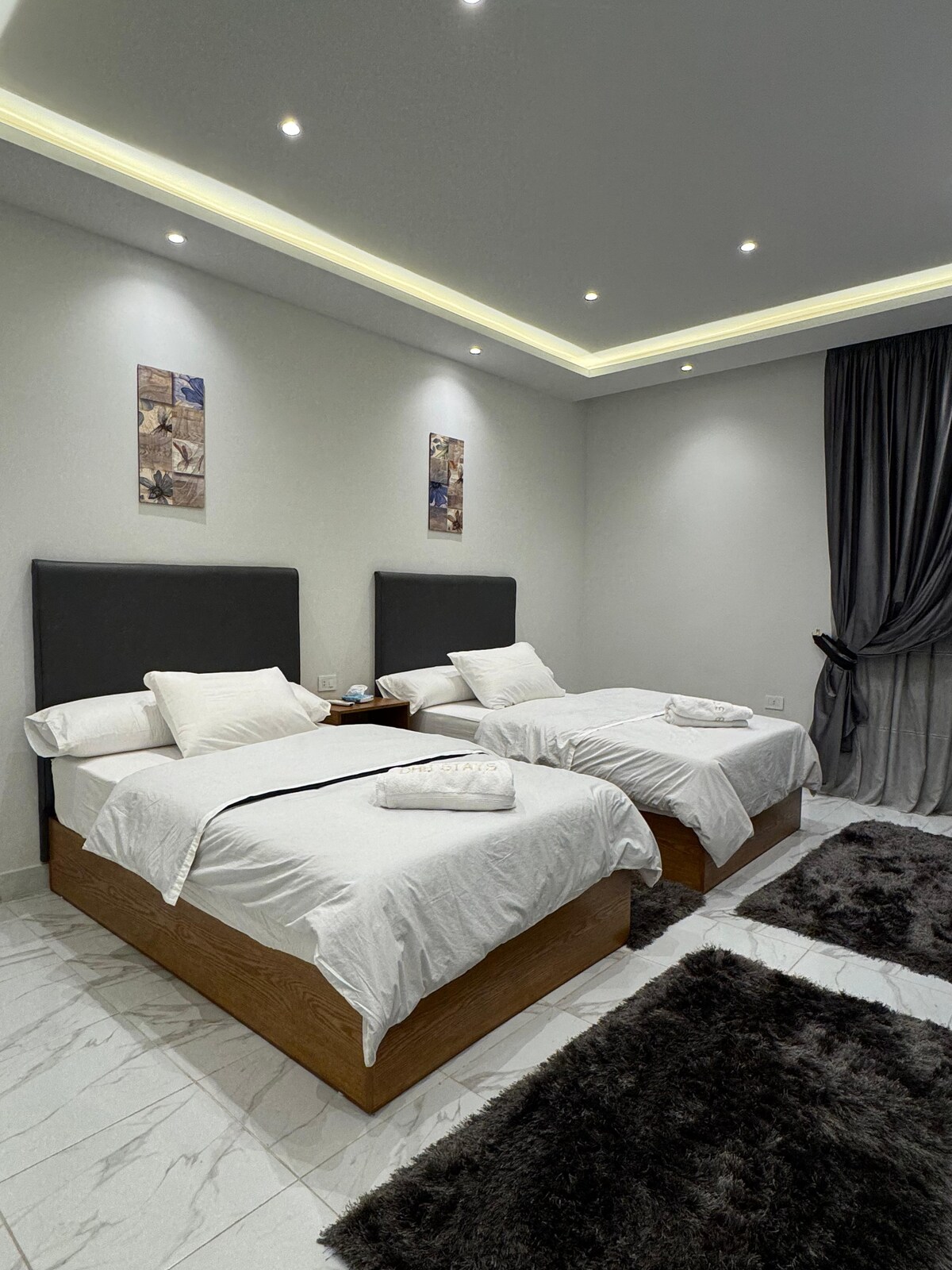 Twin bedroom — singles made up, towels folded
